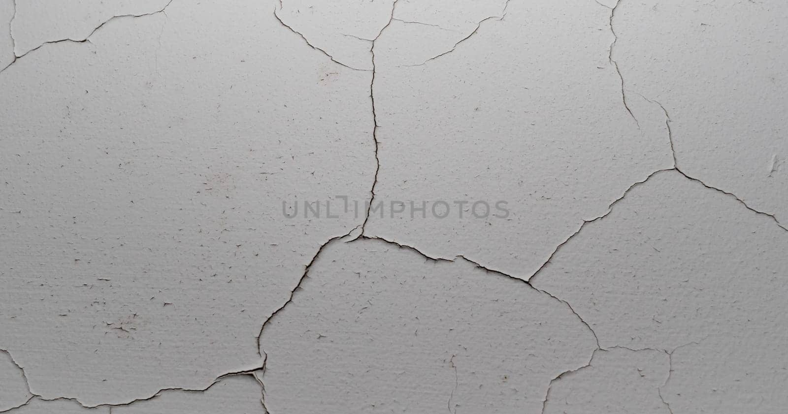 Old white cracked plaster wall surface for background or texture by Busker