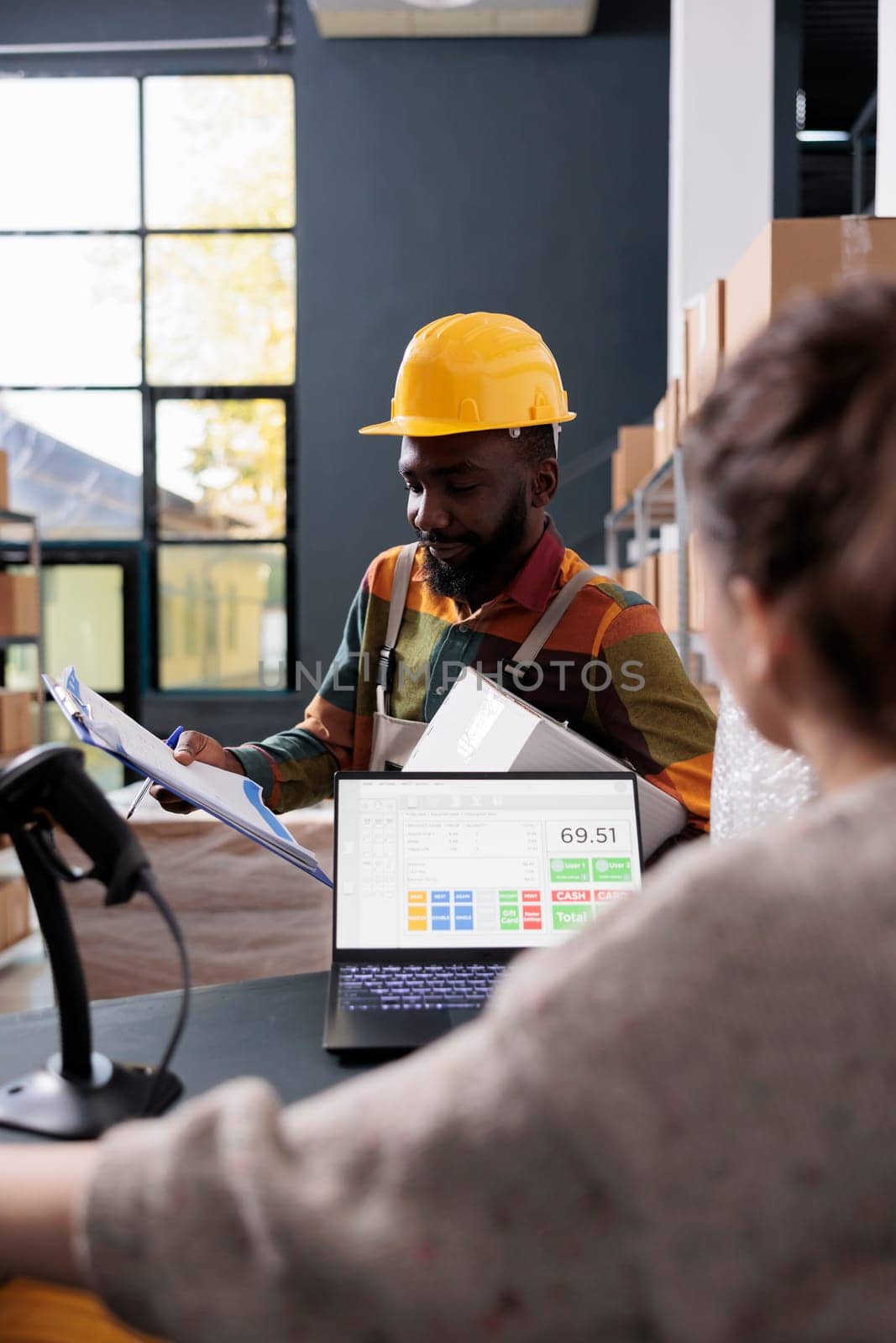 African american employee discussing merchandise checklist with storehouse supervisor, preparing customers orders for delivery. Diverse storage room team working at goods inventory in warehouse