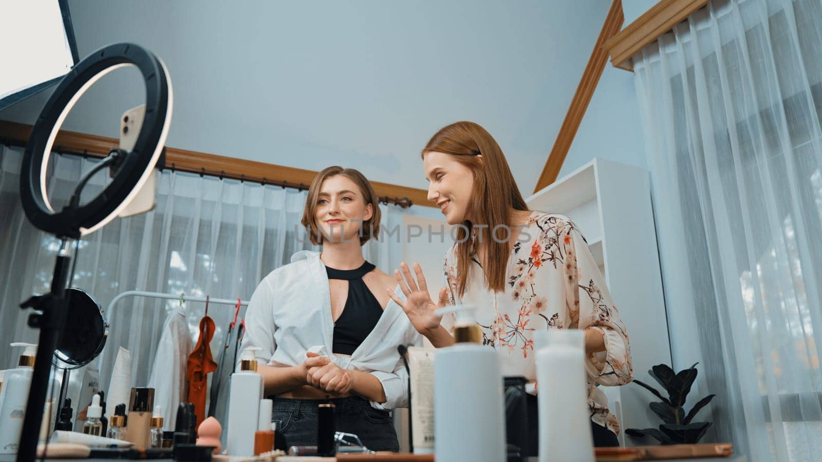 Two influencer partner shoot live streaming vlog video review makeup prim social media or blog. Happy young girl with cosmetics studio lighting for marketing recording session broadcasting online.