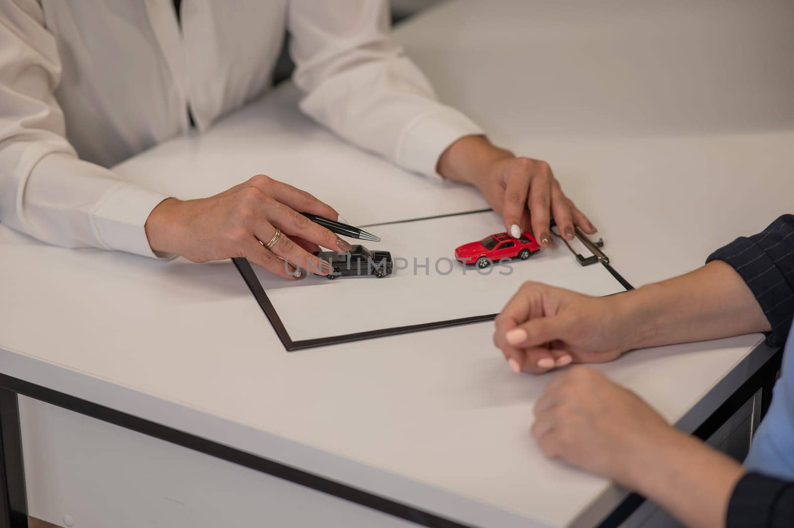 Close-up of woman's hands and car insurance agent