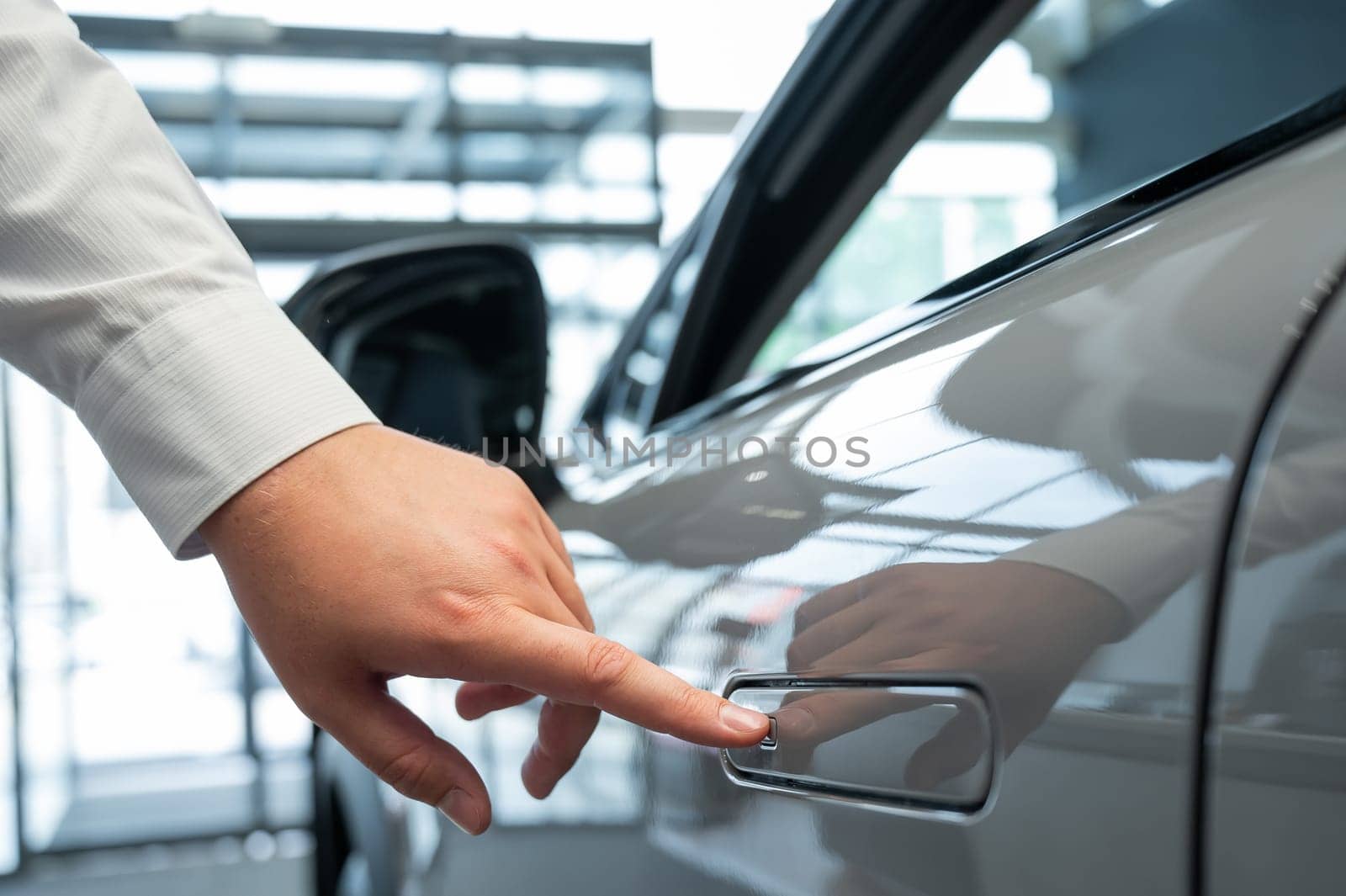 A man opens a car door with a fingerprint. Integrated handle. by mrwed54
