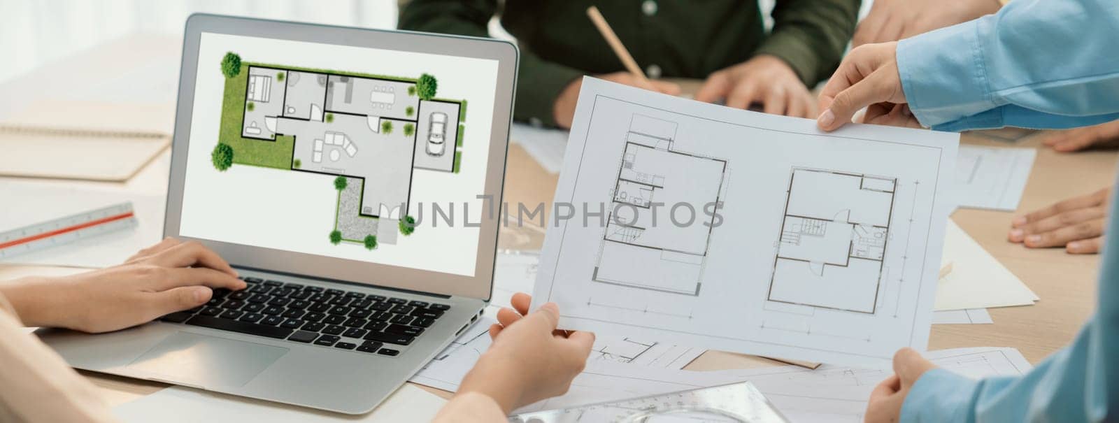 Professional architect decide the blueprint for eco-friendly house during discussion about changing blueprint plan at meeting table with architectural document scatter around. Closeup. Delineation