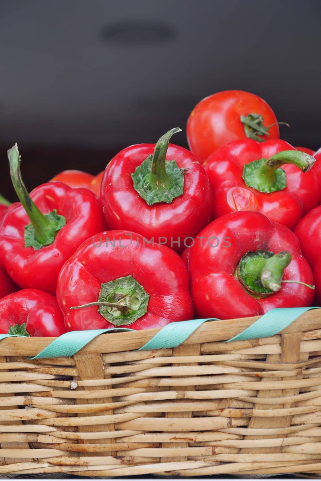 Wicker basket holds red bell peppers by towfiq007