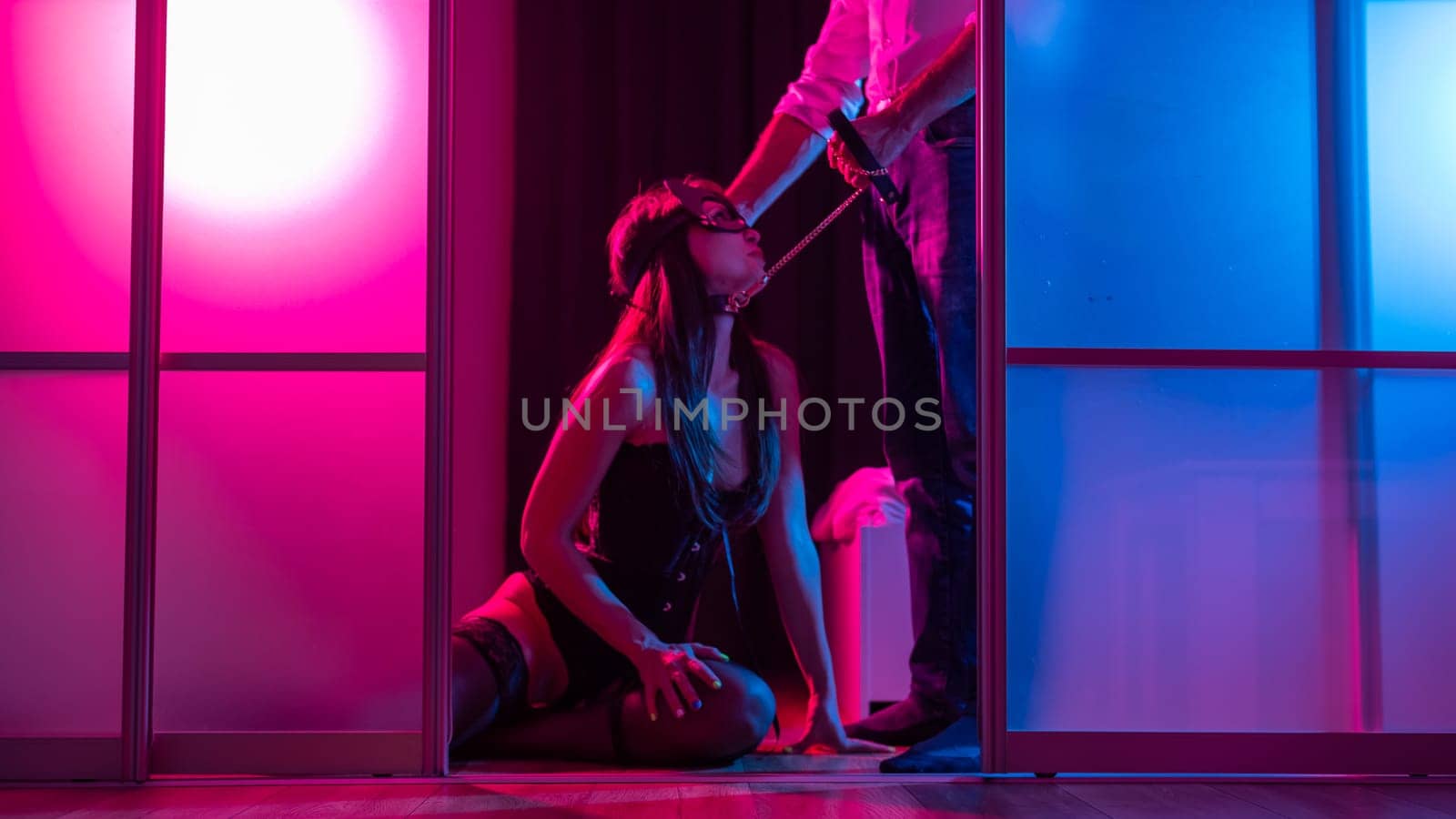 A woman is kneeling in front of a man. BDSM sex concept. Vertical photo. by mrwed54