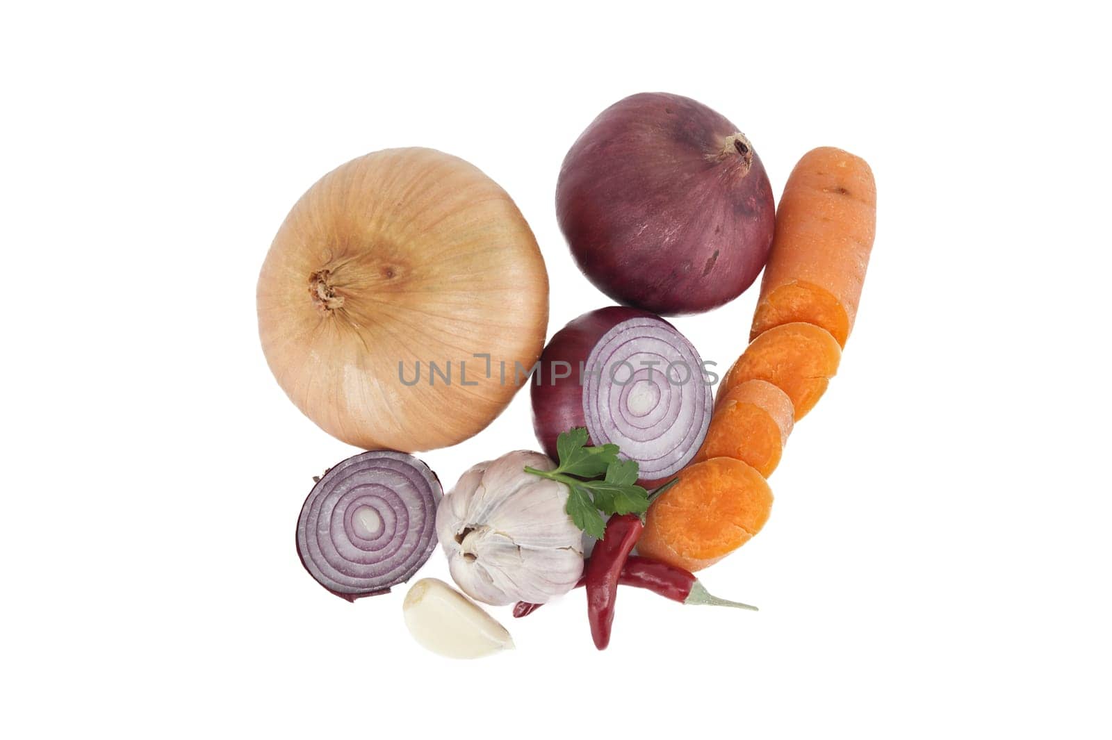 Top view of vegetables consisting red and yellow onions, red chili peppers, bulb of garlic and sliced carrots isolated on a white background