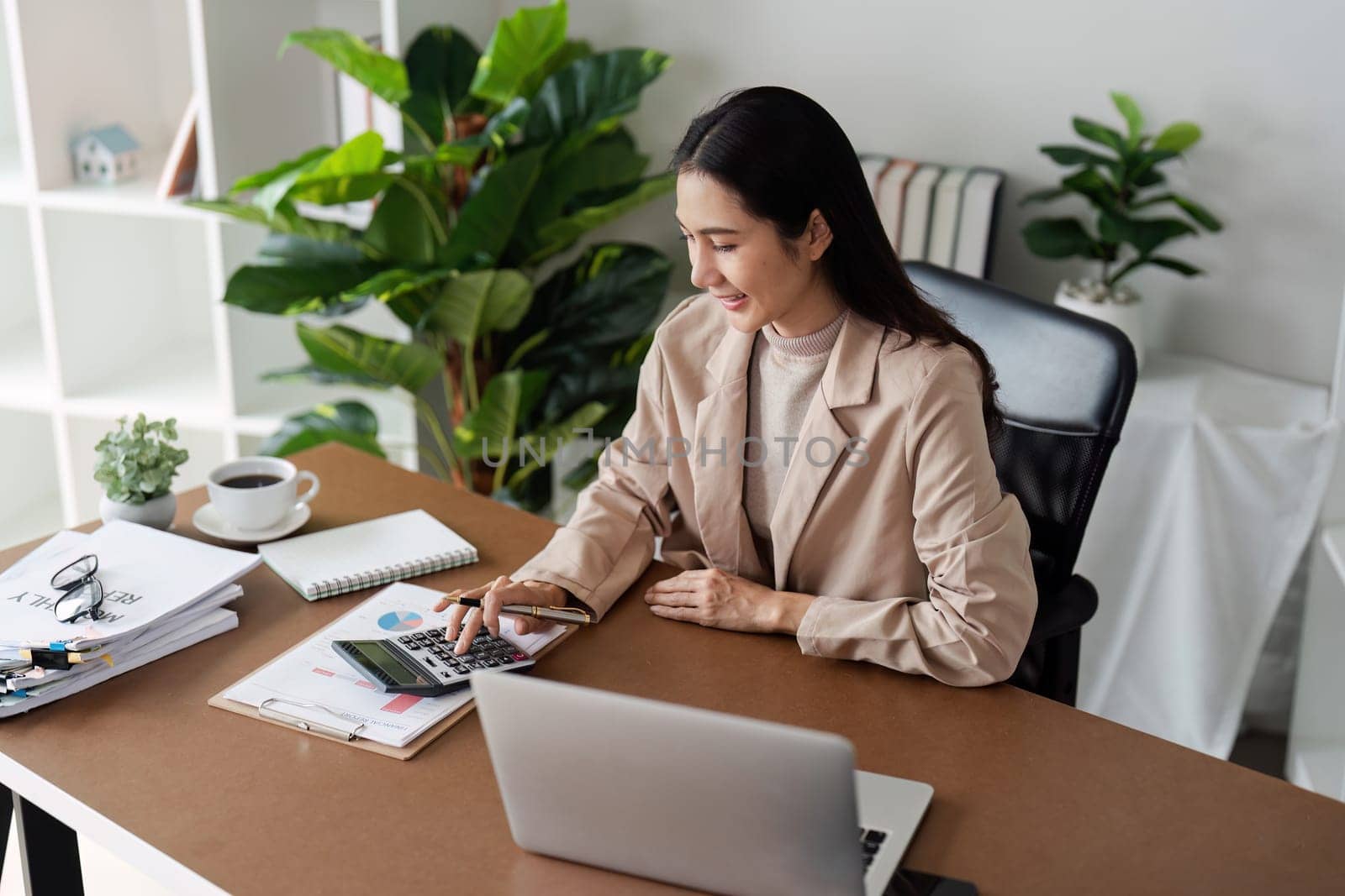 Business finance concept, Business woman using calculator to calculate business data at office by itchaznong