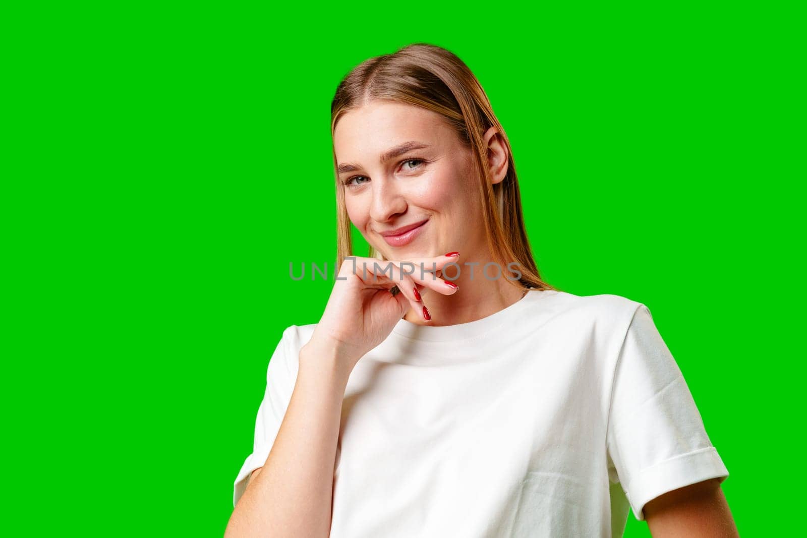 Young Woman in White Shirt Posing for Picture against green background in studio