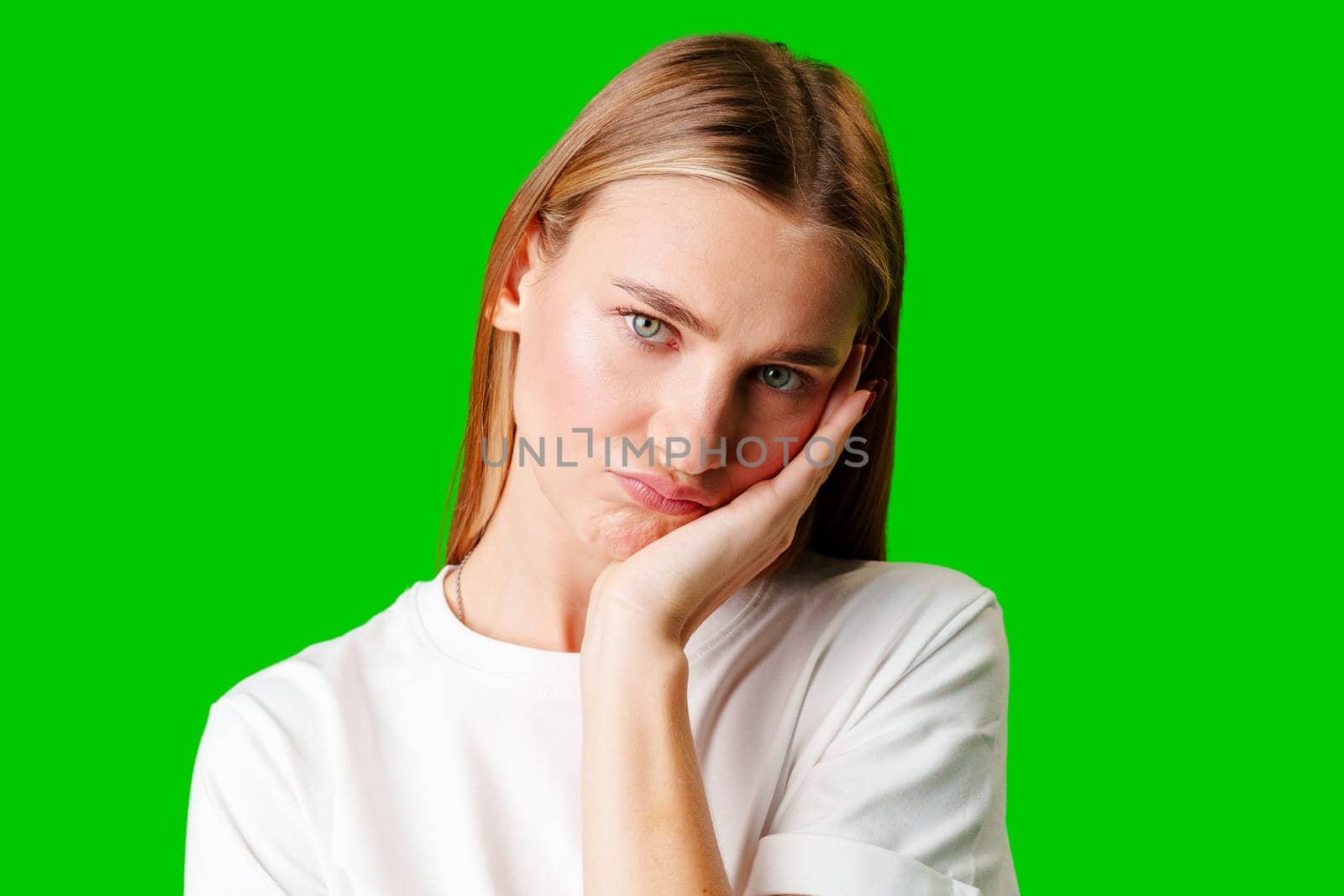 Young Woman With Pursed Lips Expressing Skepticism Against Green Screen Background in studio