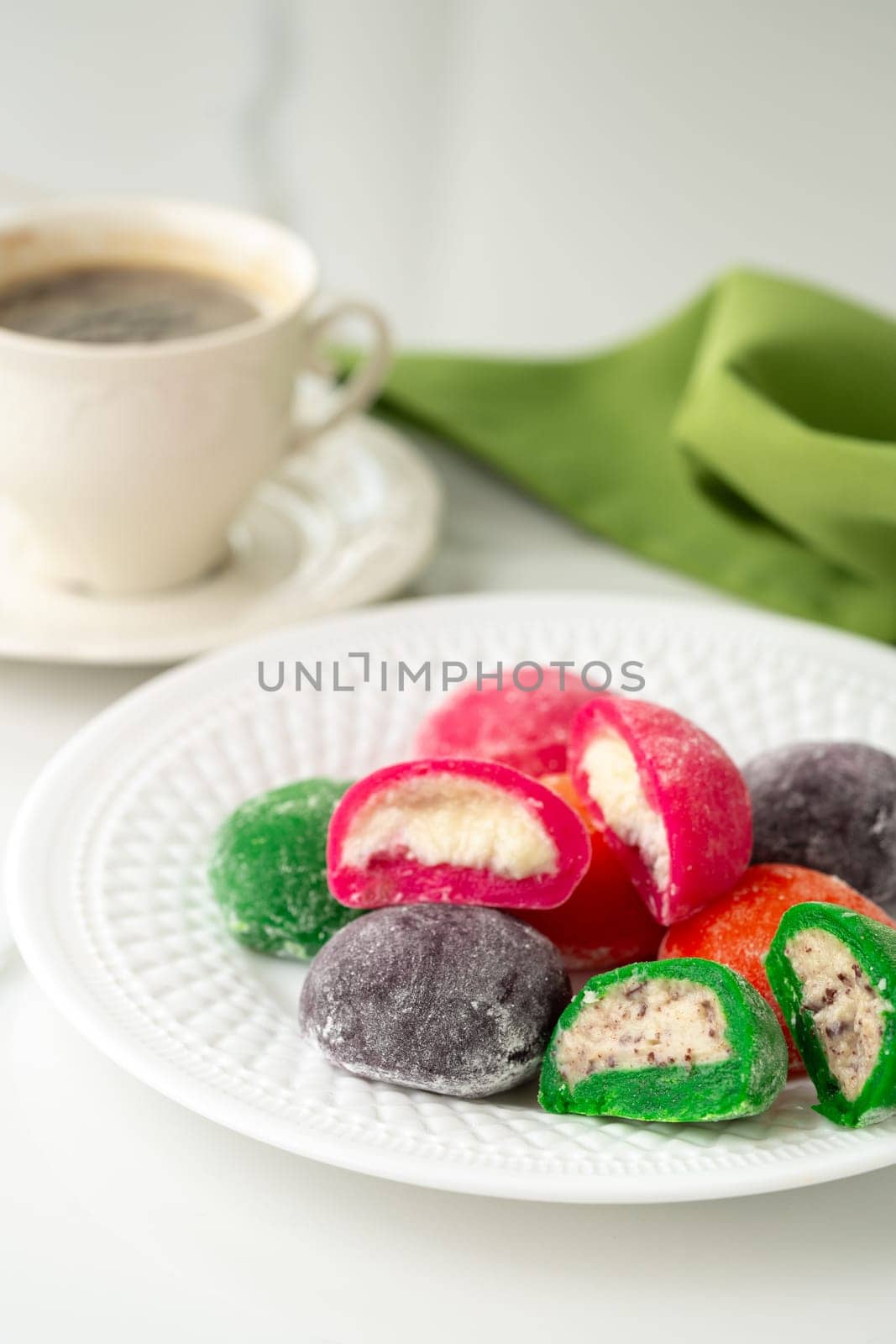 Multi-colored Japanese cakes Mochi in a white plate close up