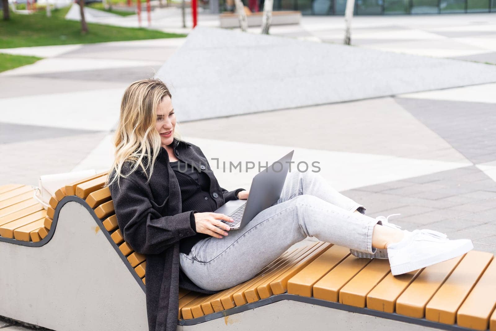 Businesswoman working with laptop in outdoor cafe. Corporate blog. High quality photo