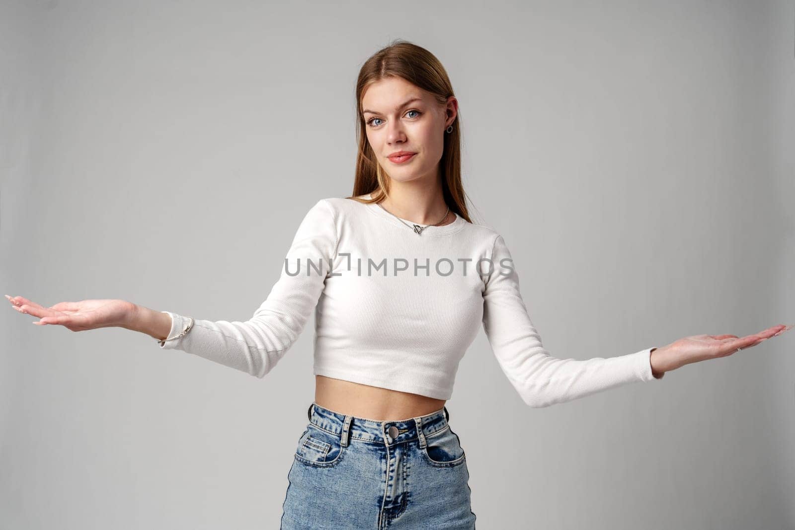 Young Woman in Blue Top Holding Out Hands in studio