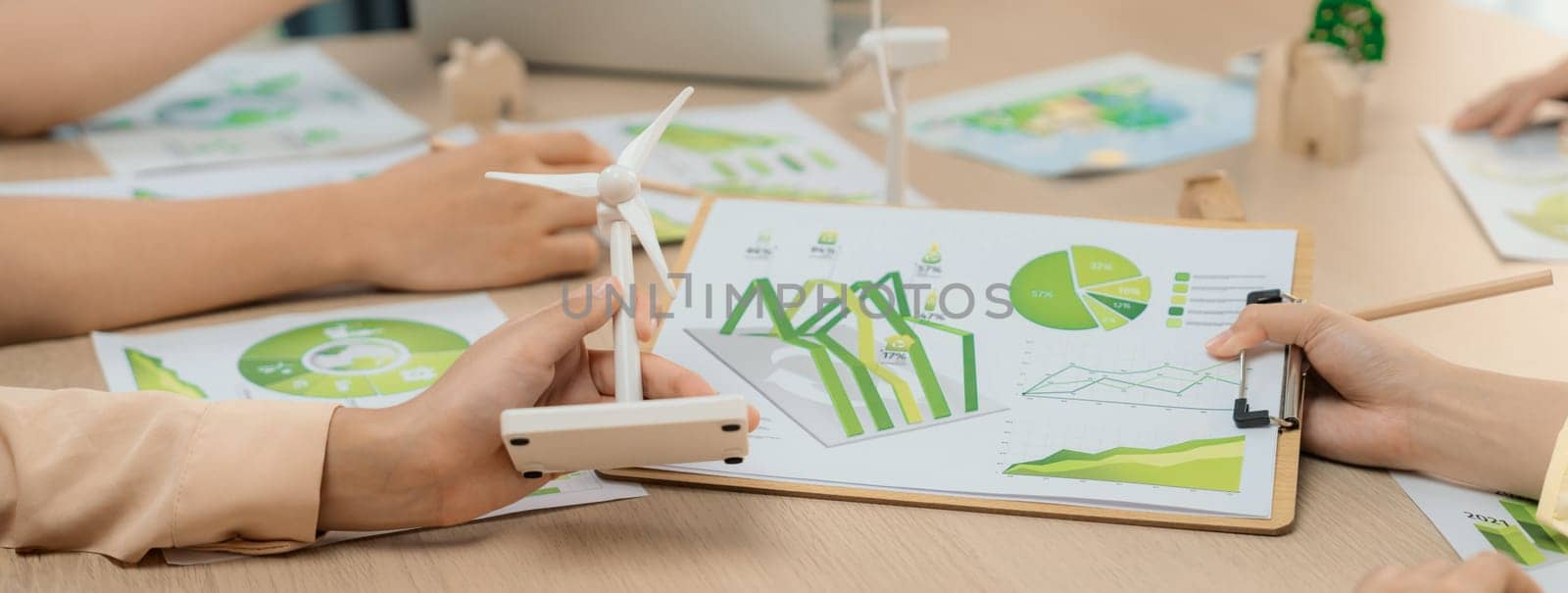 Green business meeting represented renewable energy. Skilled businesspeople discuss green business investment at table with environmental documents. Closeup. Focus on hand. Delineation.