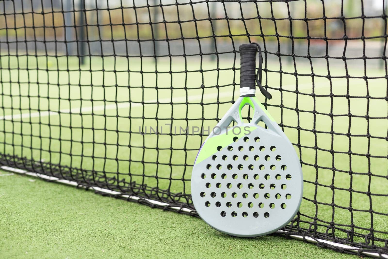 Paddle racket, next to the ball and on a carpet of the play area. High quality photo