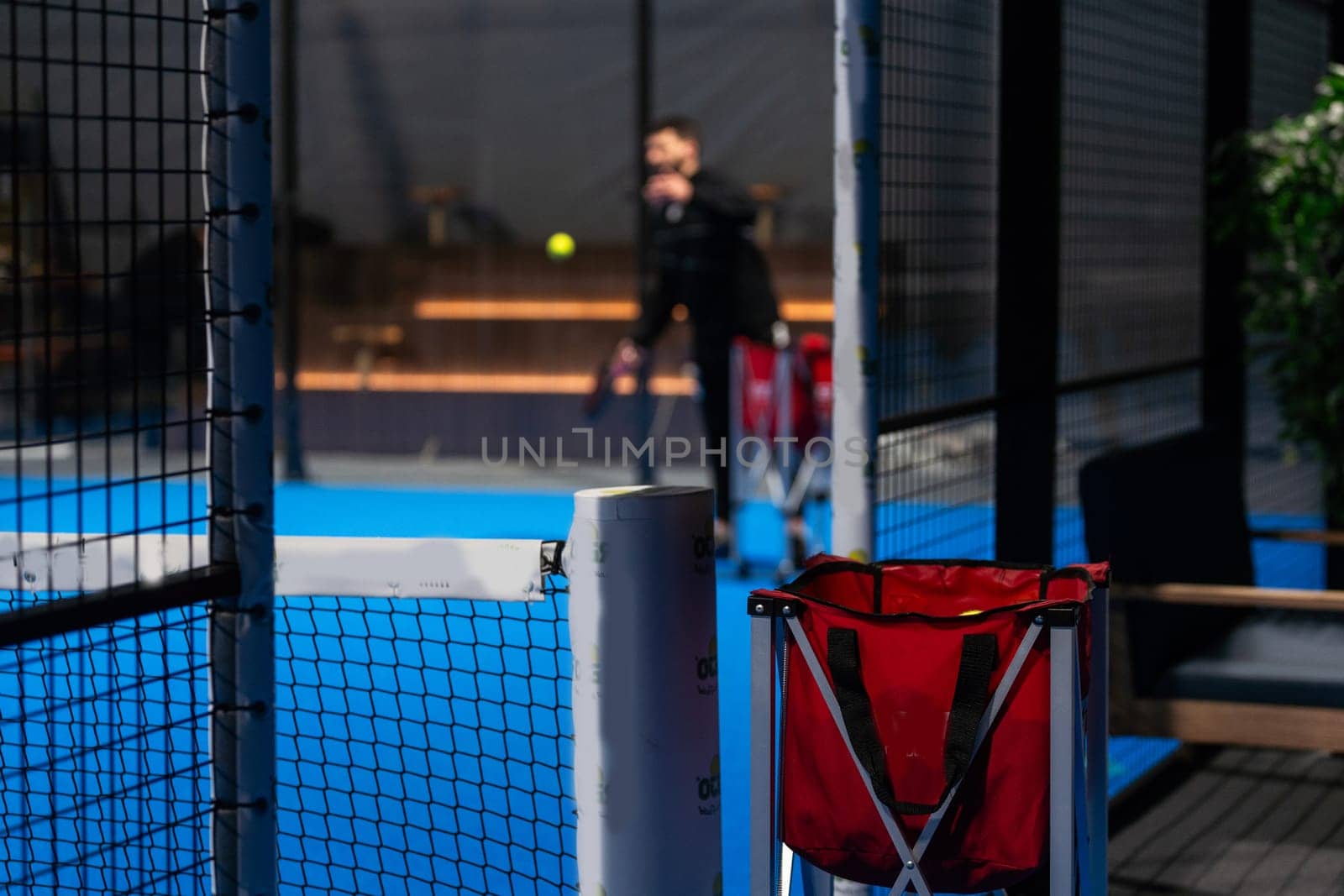 Twoo balls next to the net of a blue paddle tennis court. Sport healthy concept. High quality photo