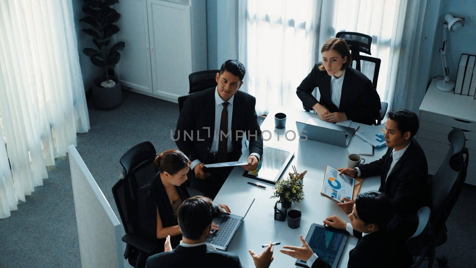 Top view businesspeople placed tablet at table and planning strategy while diverse team discuss about financial plan. Group of diverse team brainstorm marketing idea at meeting table. Directorate.
