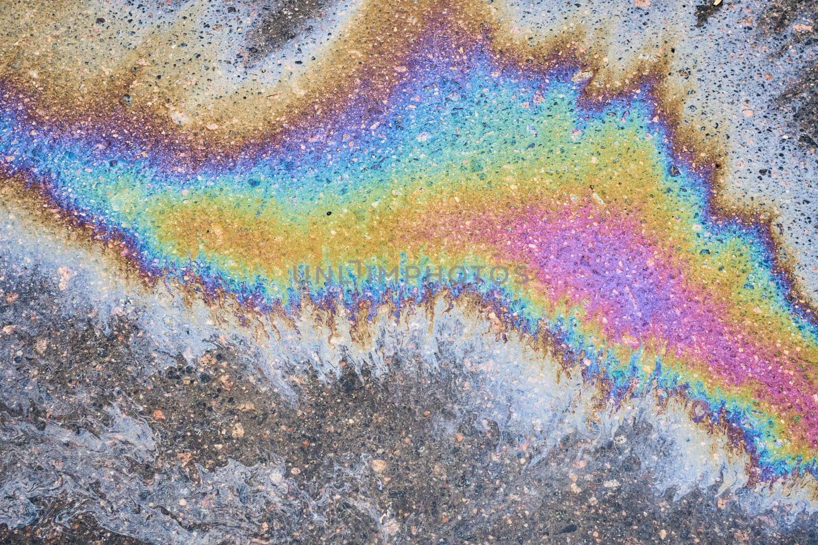 An area of leaked fuel or oil on the roadway. by AliaksandrFilimonau