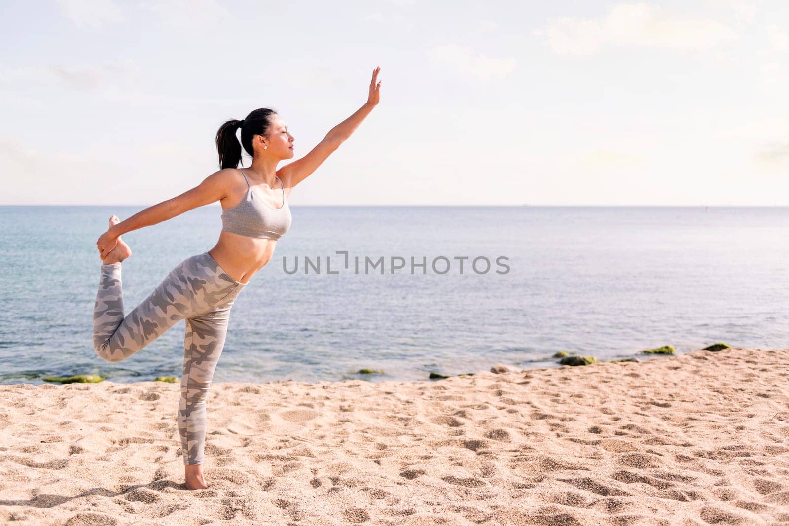 woman exercising on the beach with yoga poses by raulmelldo