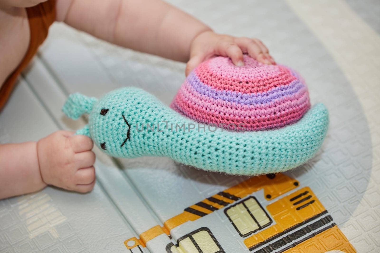 baby plays with a knitted toy in the nursery by Viktor_Osypenko