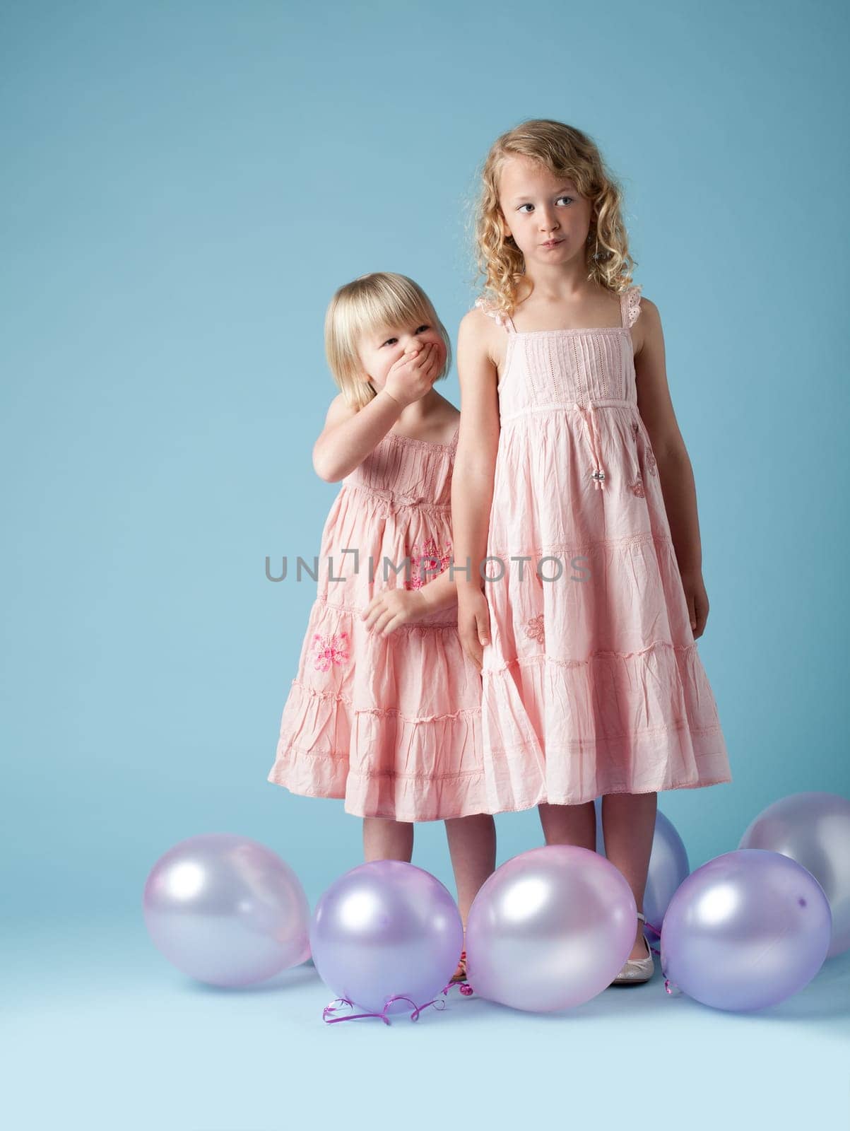 Kids, sisters and studio with balloons for fashion or development, laugh or thinking with clothes. Children, girls and inflatable on backdrop with style for youth, happy in London or England with fun.