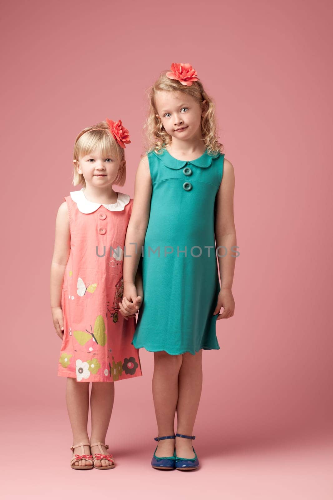 Portrait, studio background and siblings for fashion with development, vintage clothes and holding hands. Family, love and together with style inspiration by pink backdrop for kids with retro dress by YuriArcurs