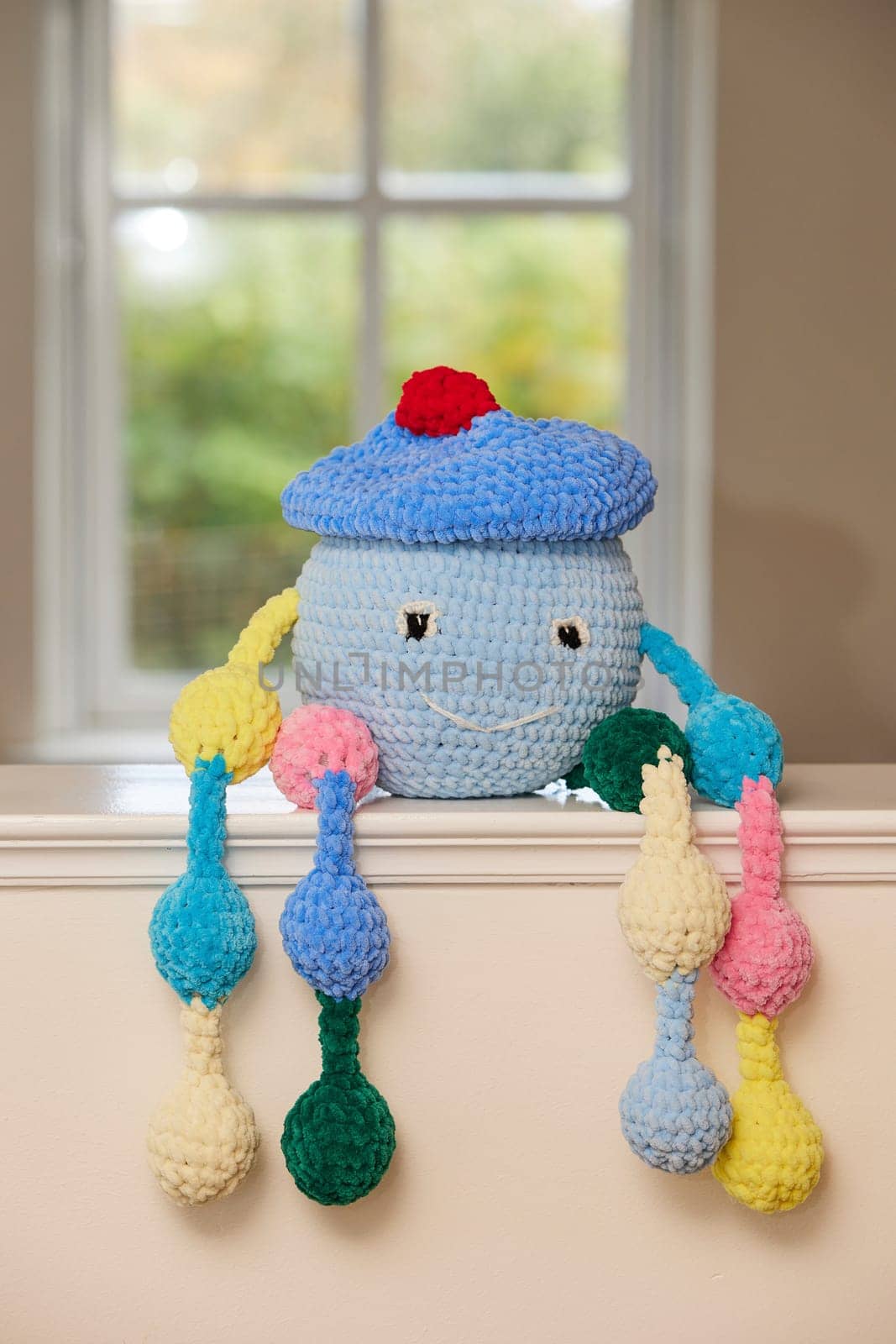 Cute knitted toy at home in the kitchen.