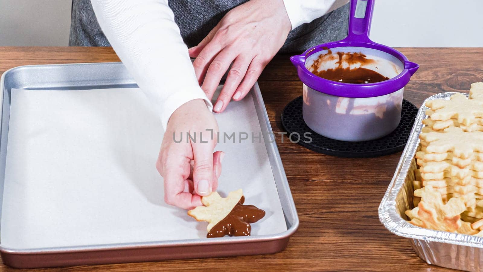 Crafting star-shaped holiday cookies dipped in chocolate and sprinkled with variety of toppings.