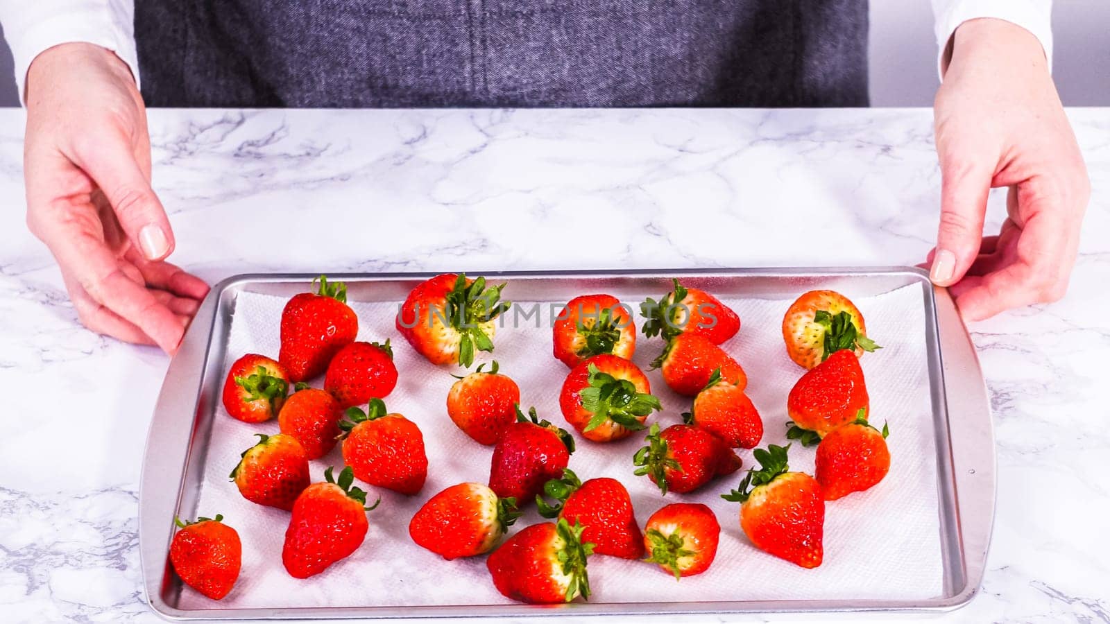 Washed Strawberries Drying on a Paper Towel-Lined Baking Sheet by arinahabich