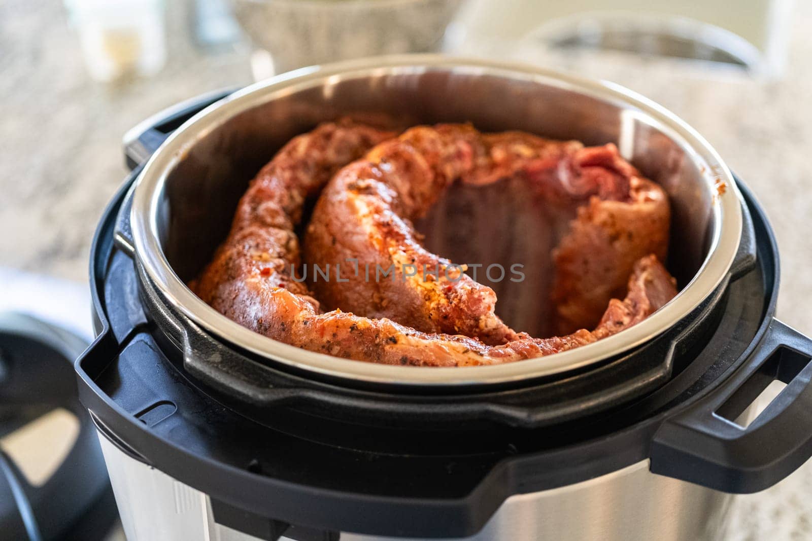 In a sleek modern kitchen, we are adding an extra layer of flavor to succulent baby back ribs by infusing them with a medley of spices in a multicooker-a mouthwatering feast in the making.