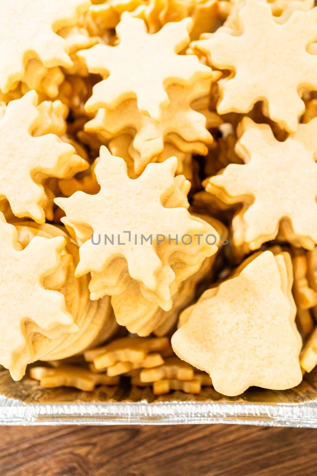 Golden-hued cookies shaped like snowflakes, intricately stacked.