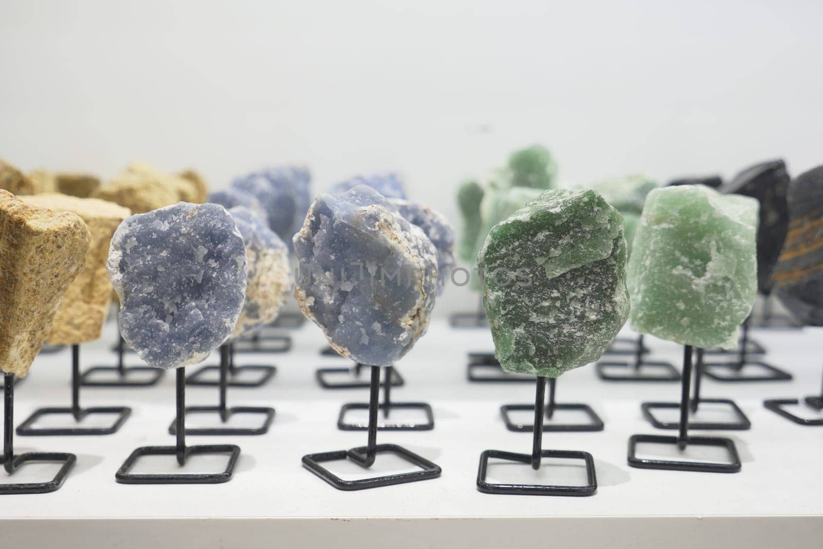 Various rocks are showcased on a table for art display.