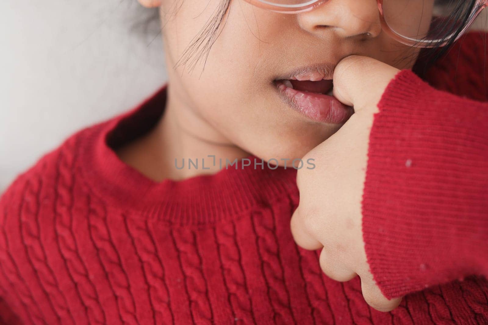 child girl biting her nails at home
