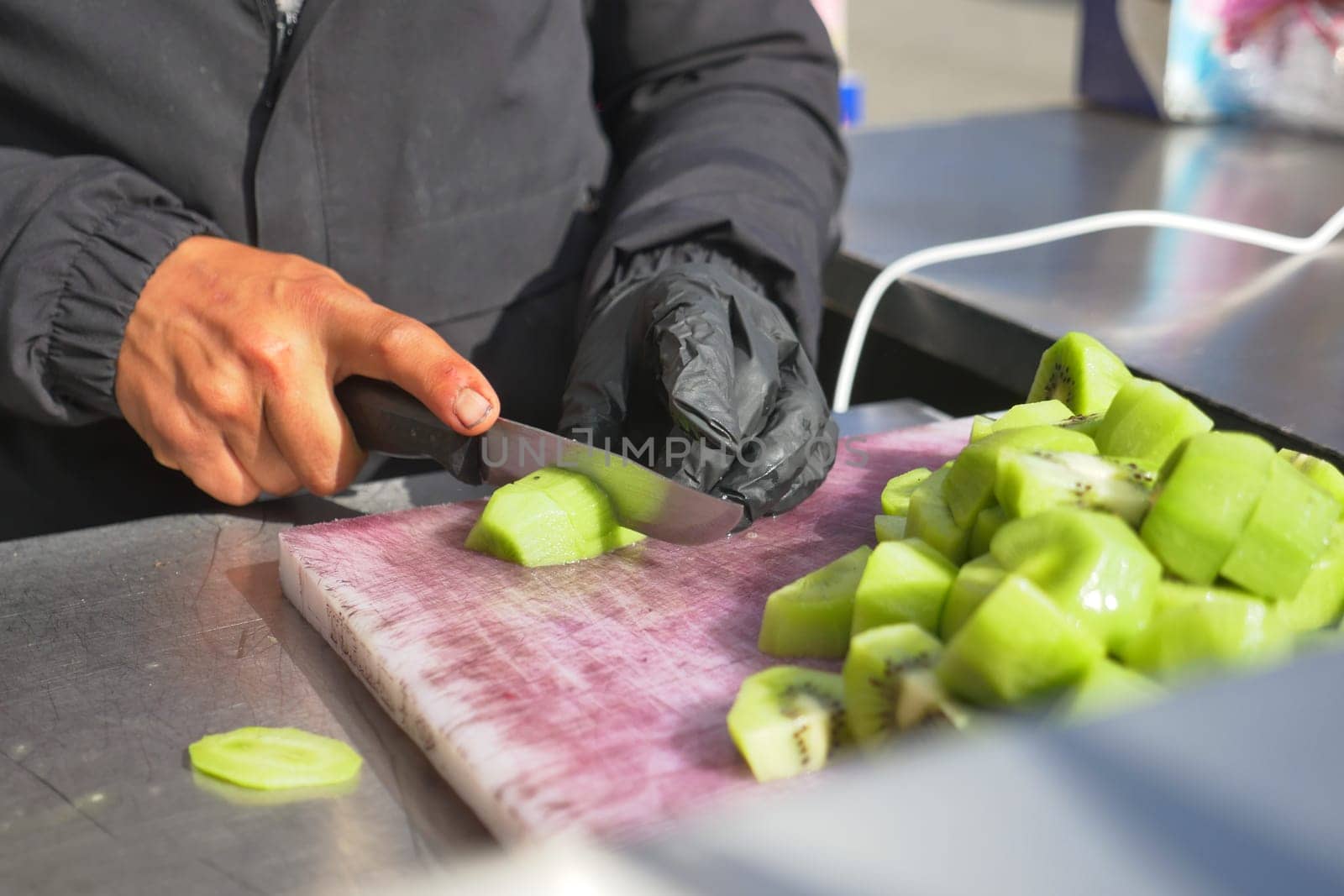 cutting Ripe kiwi fruit on a chopping board .
