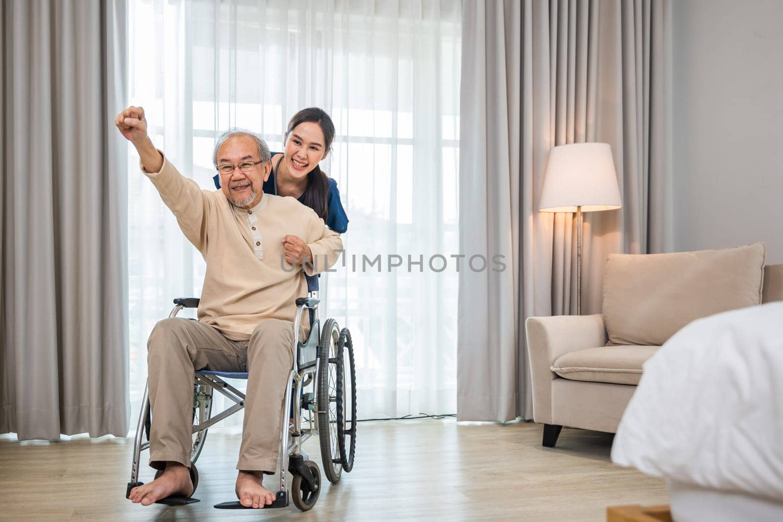 Asian senior retired old man sitting on wheelchair having fun with young woman nurse, Happy curator person doctor pushing and running elderly patient freedom raising arm, sanatorium