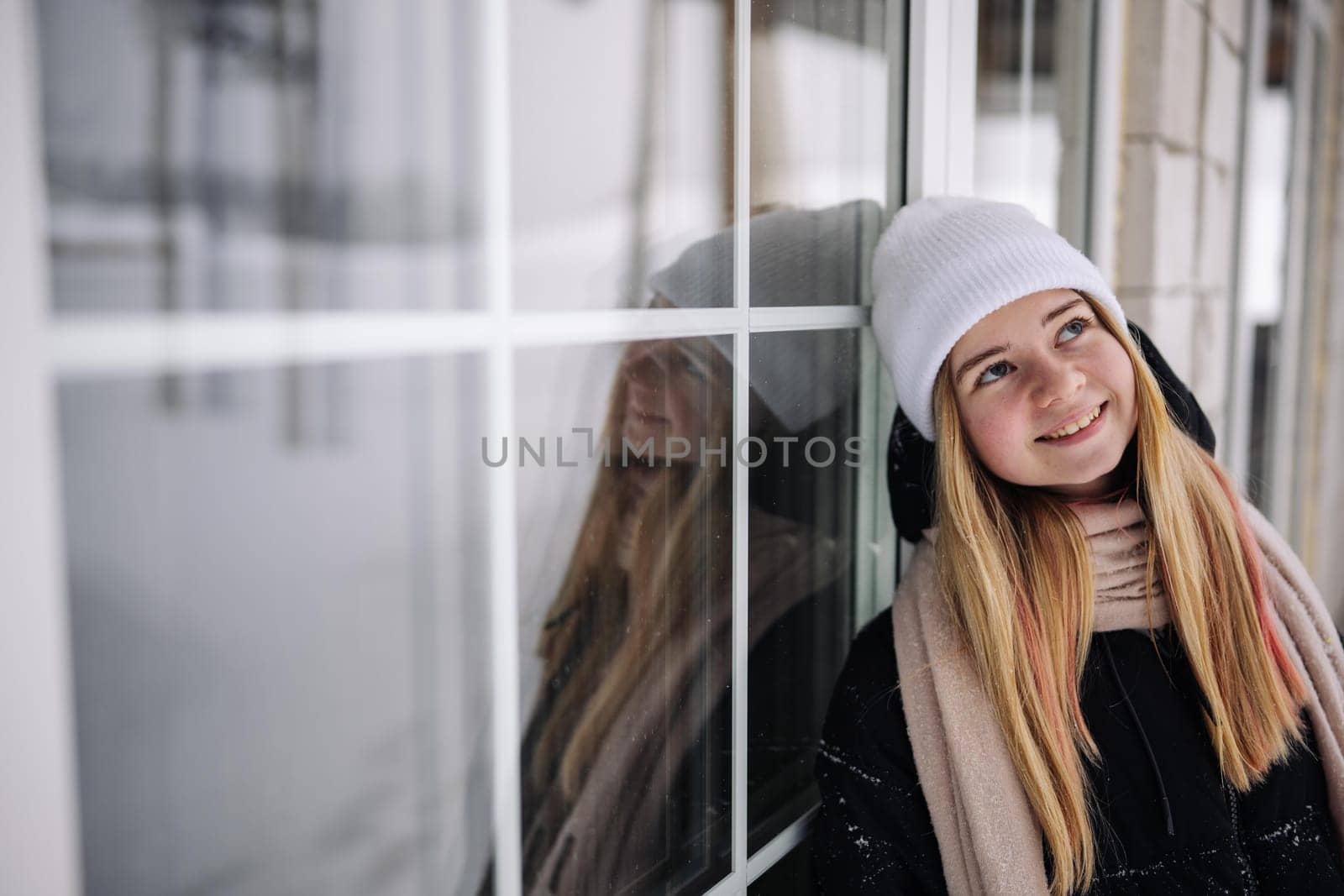 Portrait of a teenage girl at the windows of her home. by DovidPro