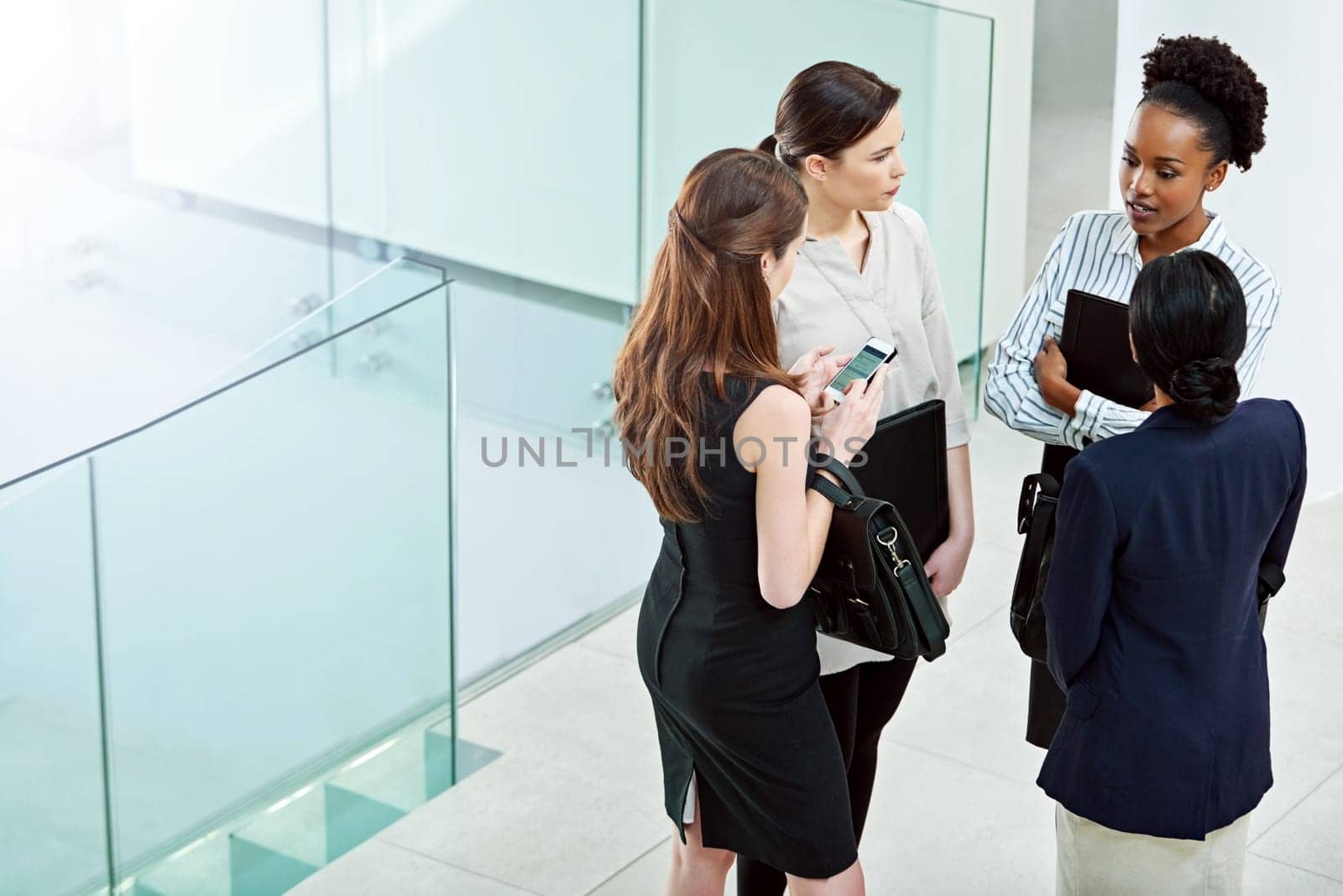 Business people, planning and talking together in lobby, teamwork and women for conversation. Employees, high angle and speaking on company growth, communication and support or collaboration on idea.