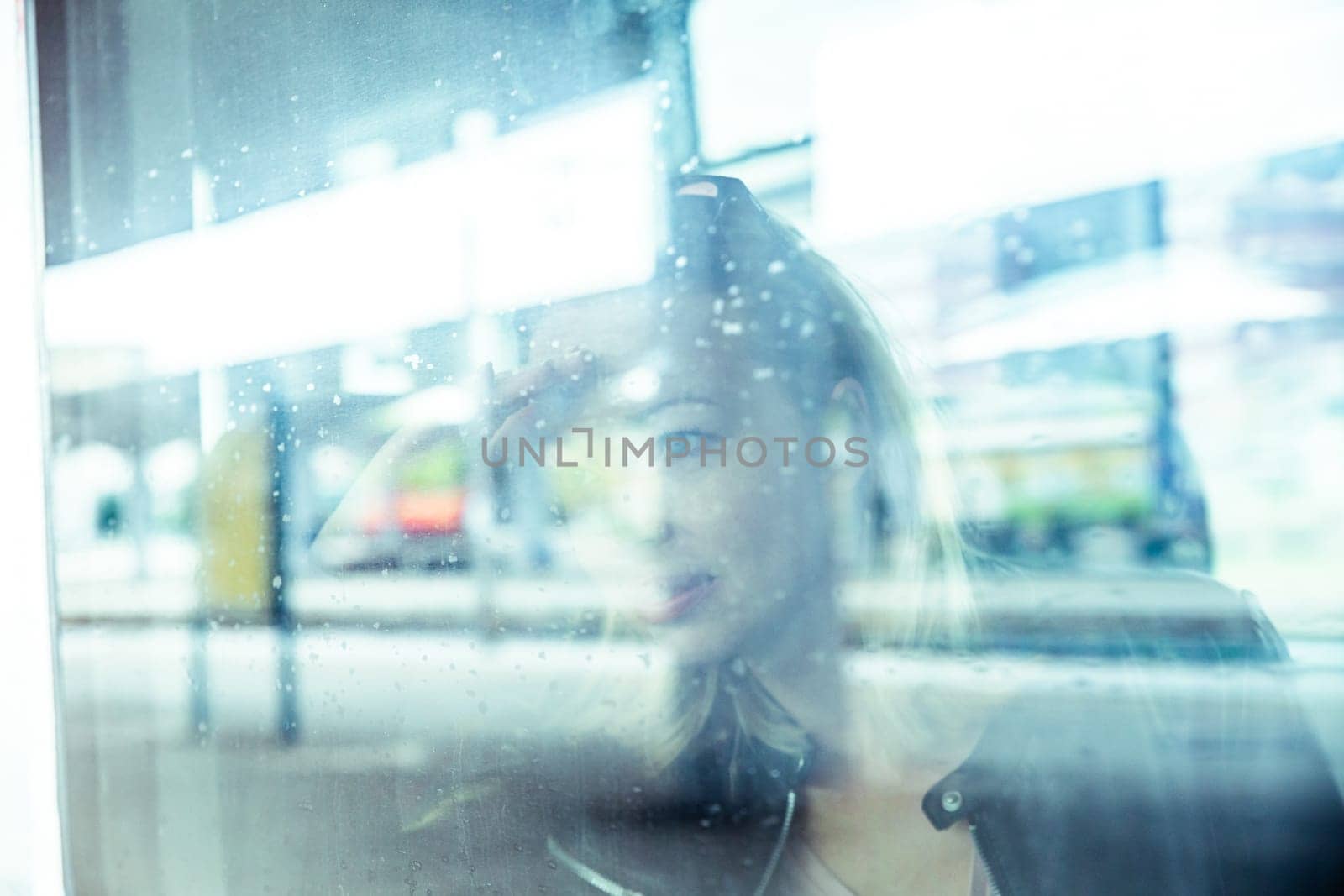 Woman traveler contemplating outdoor view from window of train. Young lady on commute travel to work sitting in bus or train