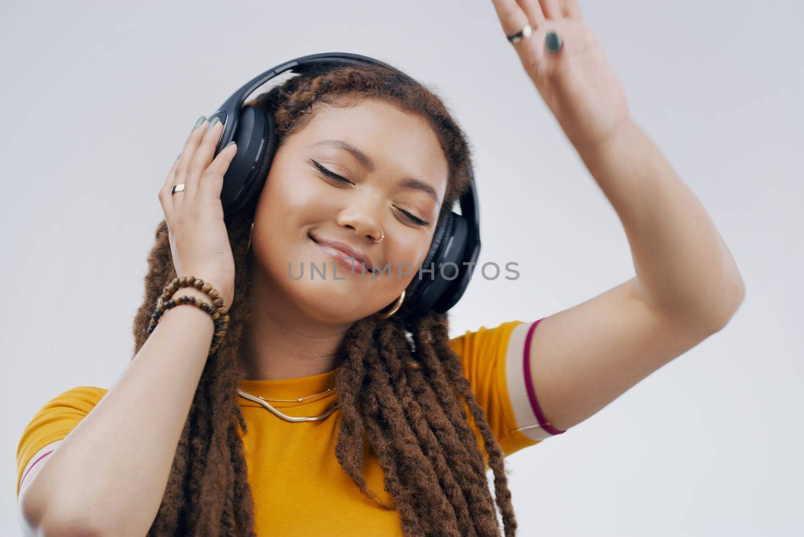 Woman, studio or dance with headphones in closeup for music, streaming or listening with happiness. Female student or celebrate on backdrop with audio for podcast, happy with sound wave in California.