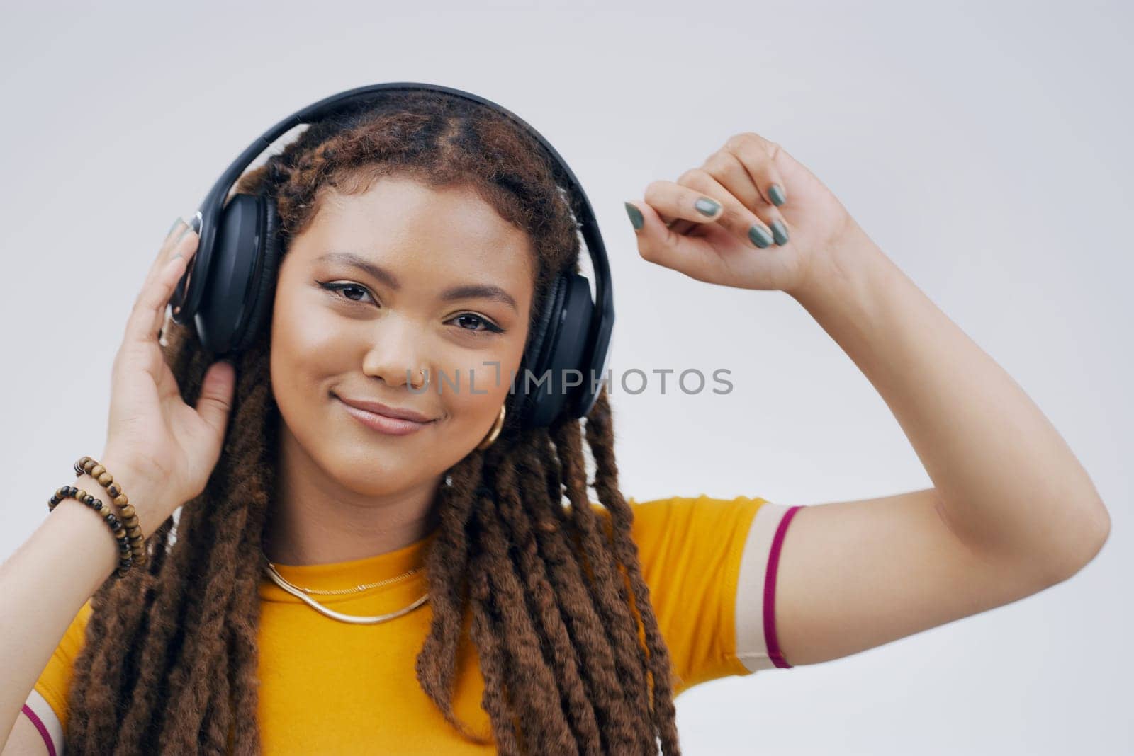 Woman, backdrop or dance with headphones or hand in closeup, streaming or music with happiness. Female student and celebrate in studio with audio for podcast, happy with sound in California or USA by YuriArcurs