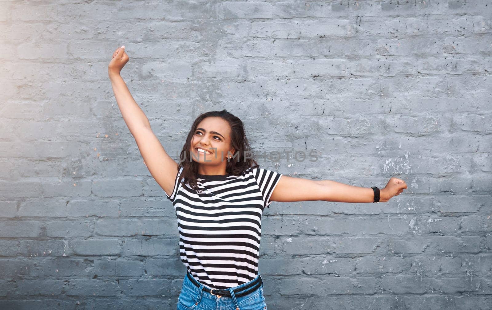 Woman, wall and stretch with smile or excited for fashion, streetwear or trendy and cool. Female person, bricks or hands with happiness for summer with style, celebration or winner in New York or USA.