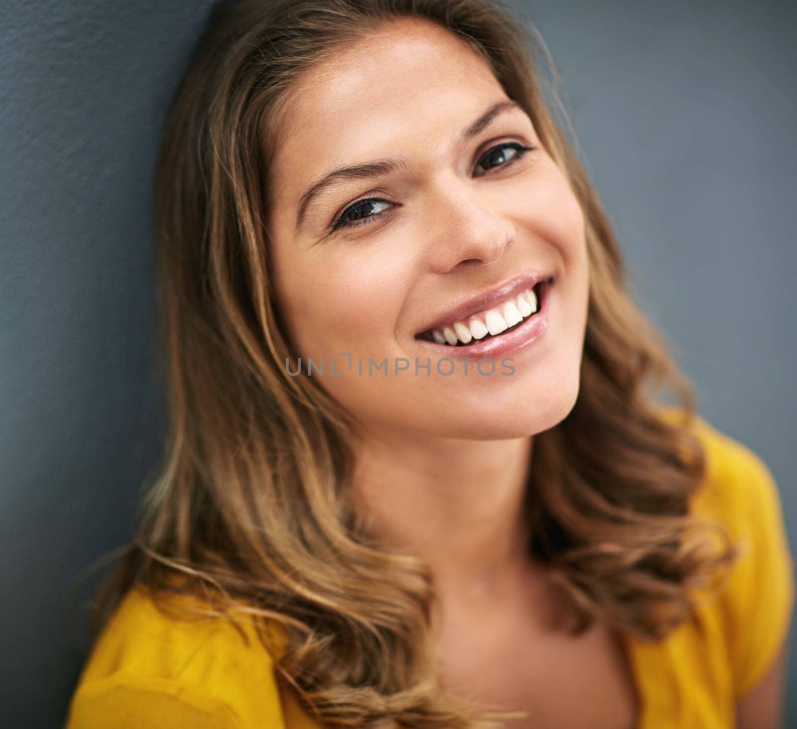 Studio, smile and portrait of woman, relax and lipstick of cosmetics, beauty and pride on wall. Grey background, makeup and girl with joy for face, confidence and cheerful for break, week and USA.