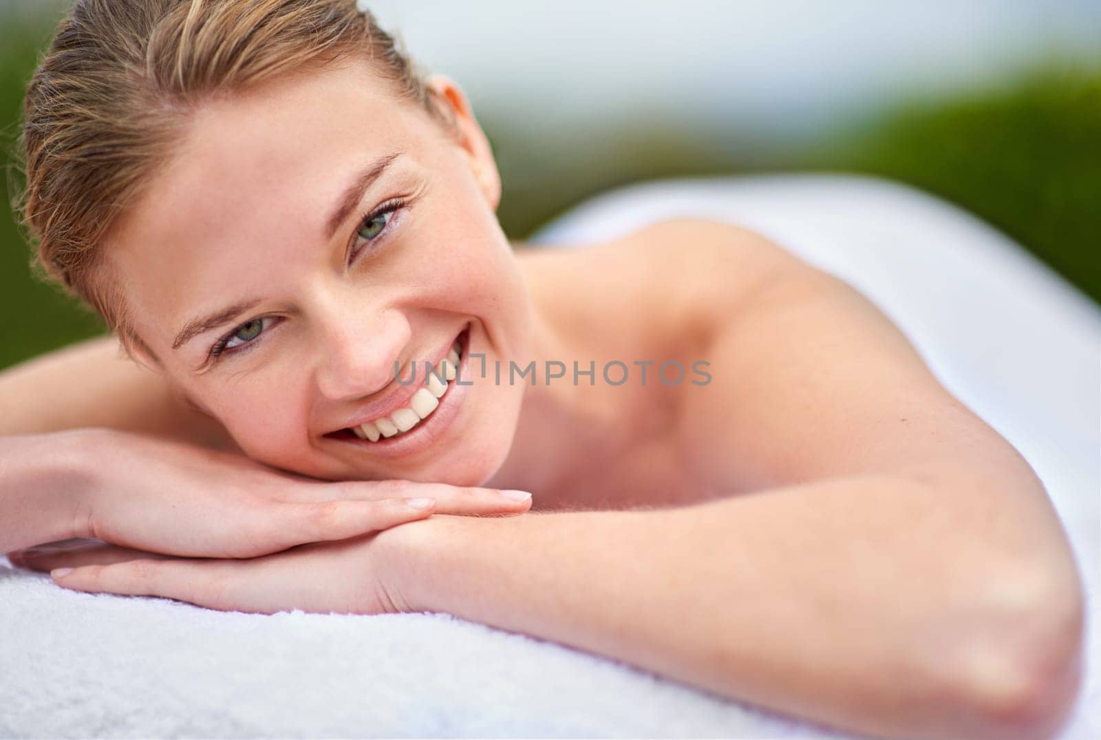Spa, happy woman and portrait on massage bed for wellness, beauty treatment or body care. Smile, relax and female person at luxury resort for stress relief, comfort or pamper on tropical holiday.