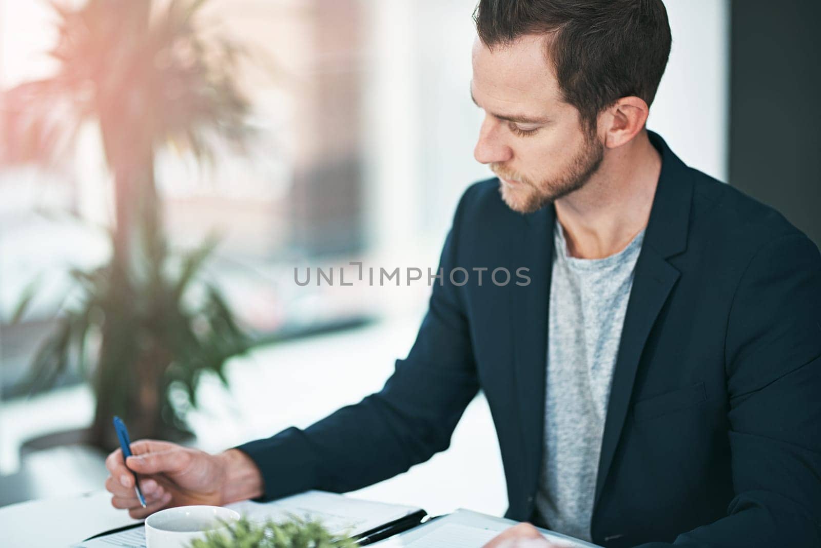Businessman, writing and documents with finance in budget planning, reports or reading accounts at office. Man, accountant or employee working on paperwork for financial statistics, growth or revenue.