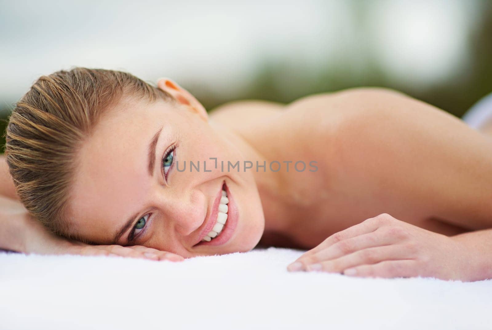 Smile, spa and portrait of woman on massage bed for wellness, beauty treatment or body care. Happy, relax and female person at luxury resort for stress relief, comfort or pamper on tropical holiday.