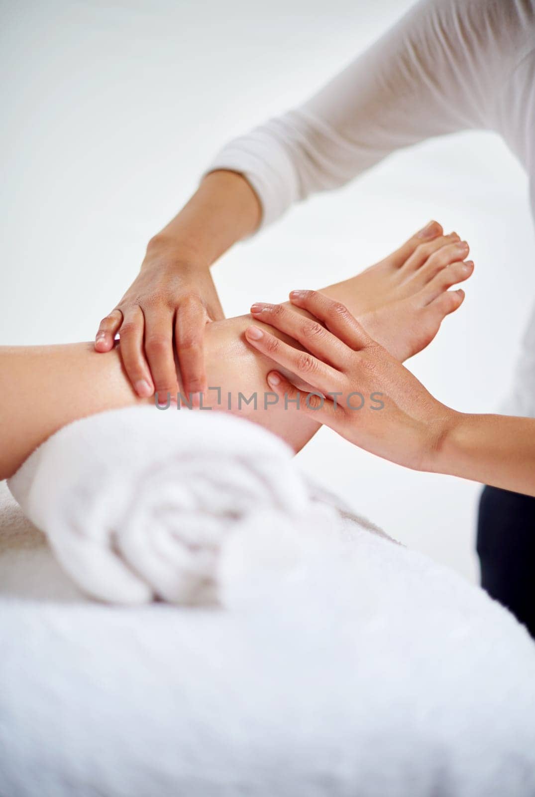 Foot, hands and masseuse with massage at spa for treatment, beauty and skincare at luxury resort with wellness. Pedicure, cosmetics and people for physical therapy, healing for self care and relief by YuriArcurs