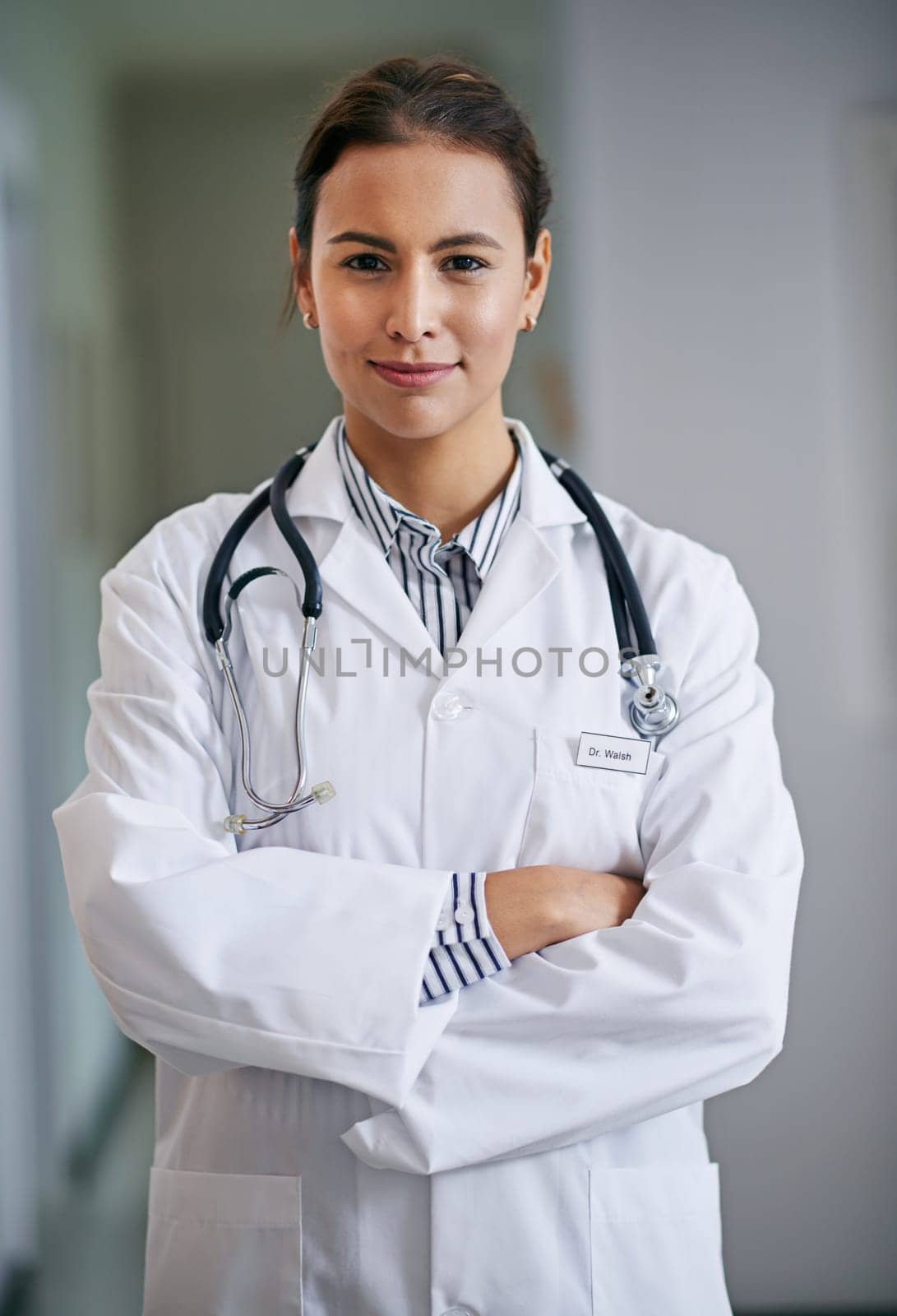 Woman, portrait and doctor with arms crossed in hospital, clinic and wellness facility with confidence in medical career. Female person, cardiologist and happy healthcare professional in Colombia.