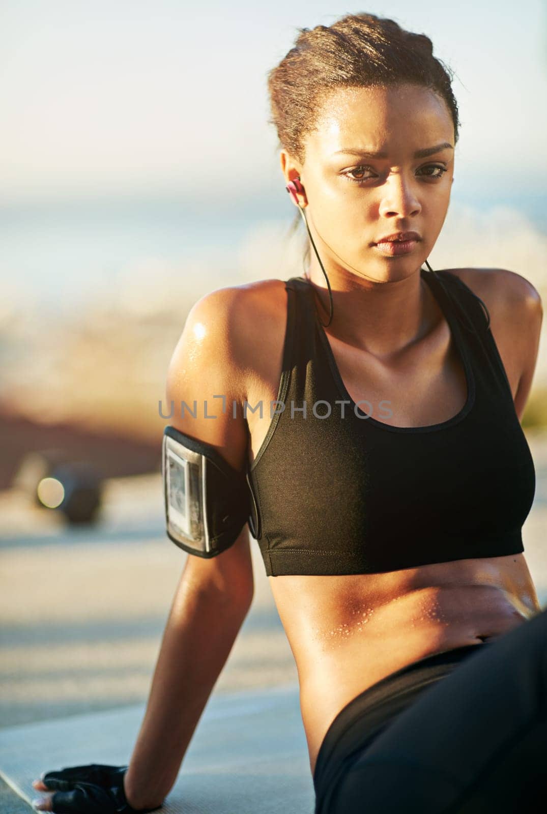 Workout, portrait and woman at sunrise with music or podcast for fitness, health and relax in nature. Earphones, sports and female athlete in park for exercise, wellbeing and training in summer by YuriArcurs