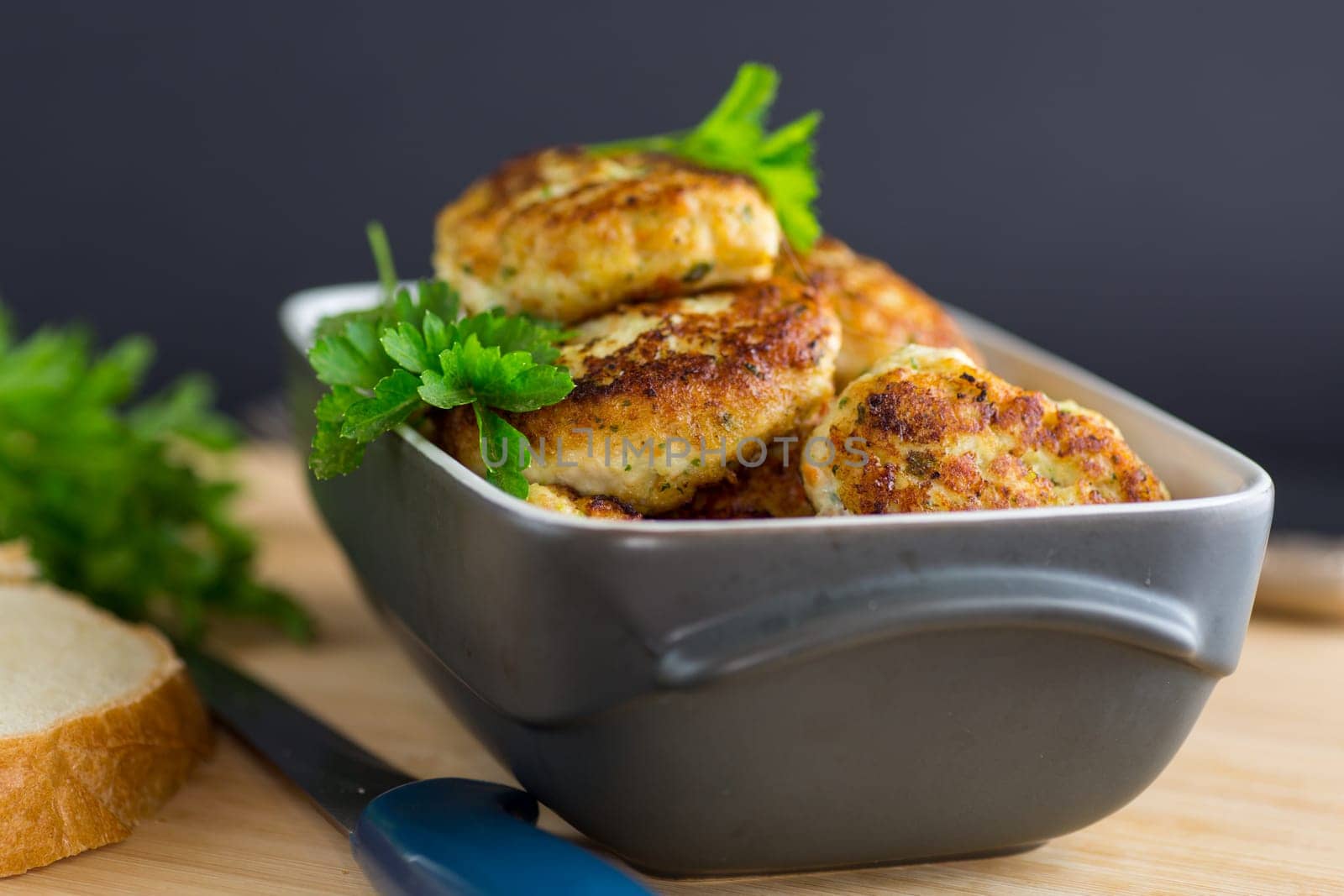 fried meat cutlets in a ceramic form on a wooden table .