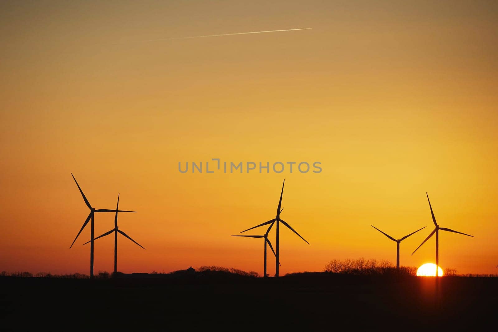 Wind turbines in the Danish countryside at sunset.