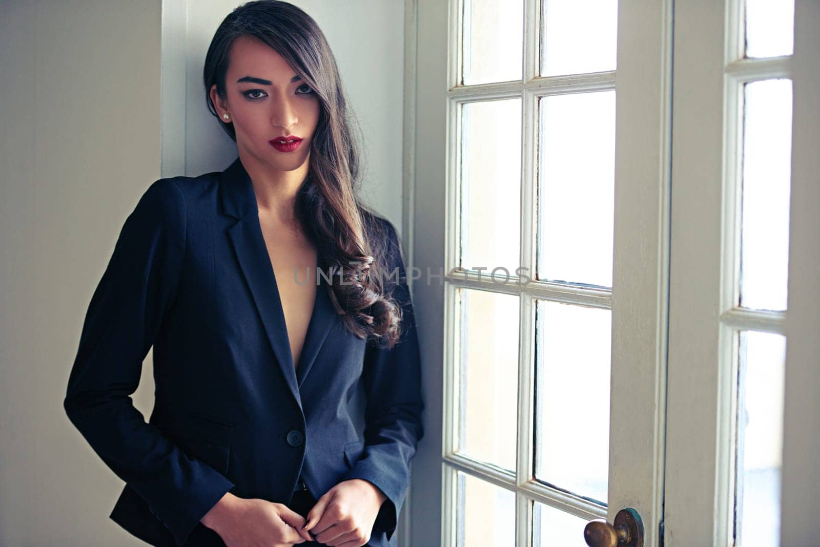 Woman, portrait and fashion suit with luxury style at window door or classy blazer, makeup or confidence. Female person, glamour and event clothes for fancy party with chic clothing, pride or cool.