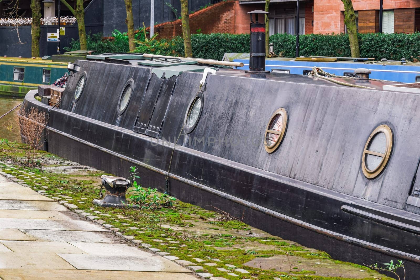 Castlefiled neighborhood canals with moored narrowboats on the waterfront in Manchester, UK.